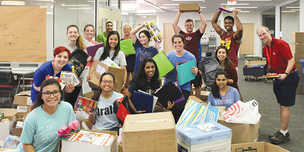 Students box donated school supplies.