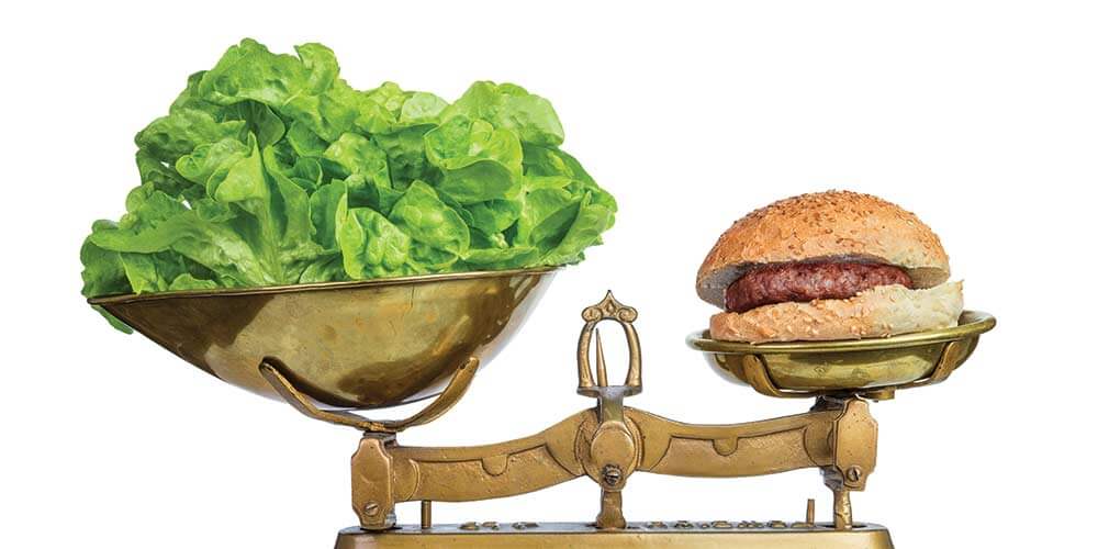 Lettuce weighed against hamburger.