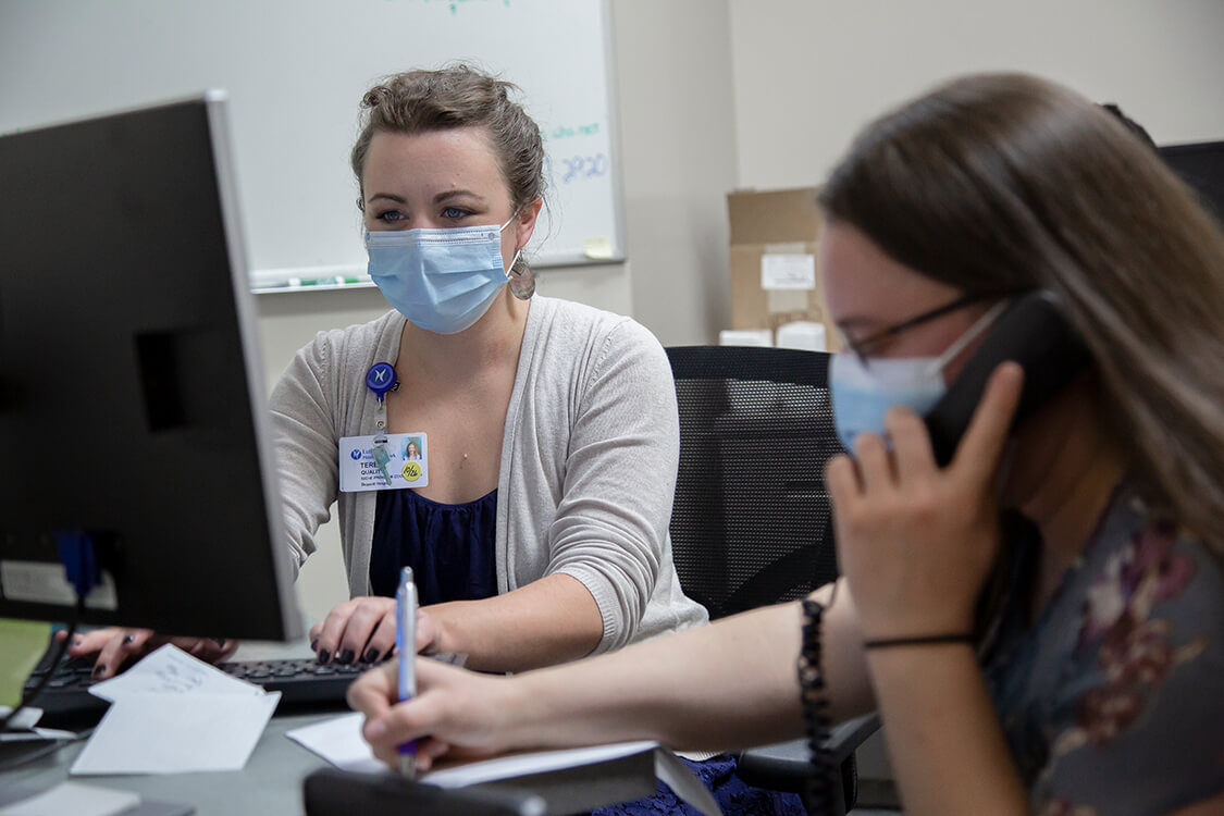Student pharmacist Lauren Conway conducts a patient call to review a list of medications and relevant issues under Teresa DeLellis’ supervision and assistance.