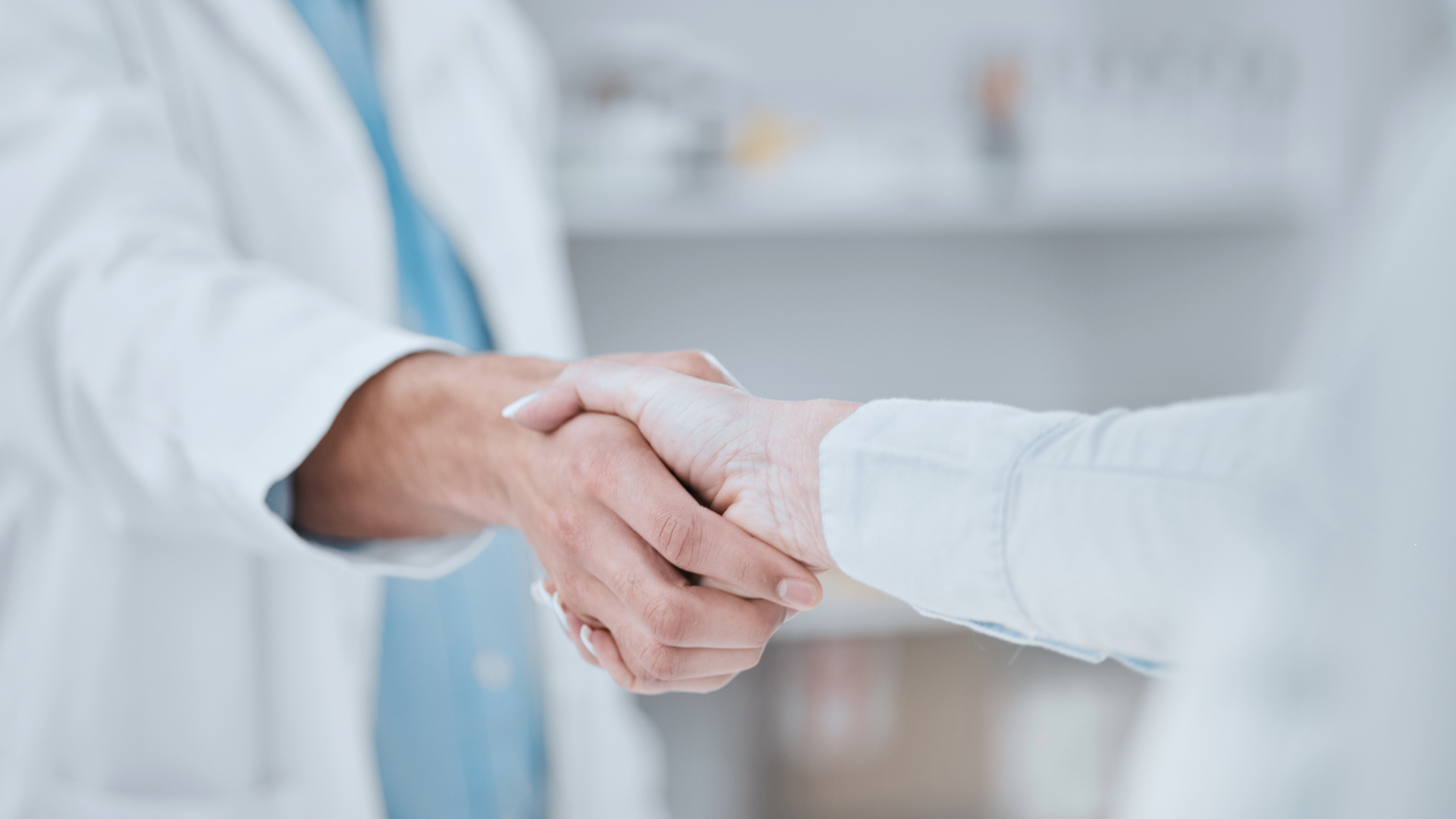 A pharmacist shakes hands with a stakeholder.
