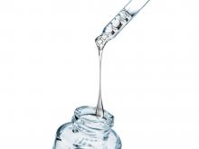 Droplet falling from dropper into glass bottle.