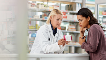 A community pharmacist discusses medication with a patient.